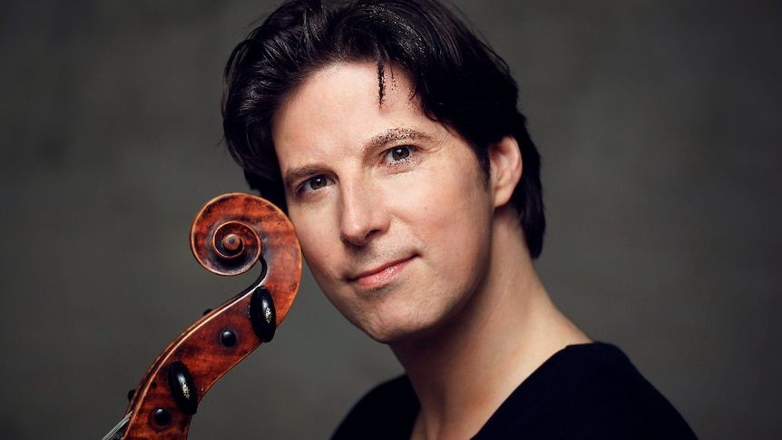 Cellist Daniel Muller-Schott posing with cello.