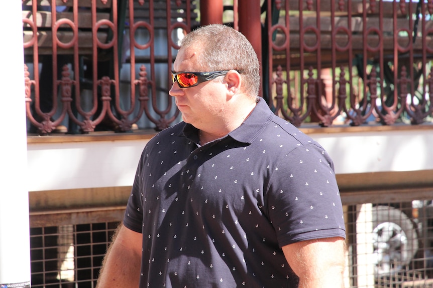 A man in a blue t shirt and sunglasses