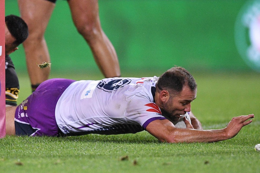 Cameron Smith dives over the line with one arm stretched out in front of him