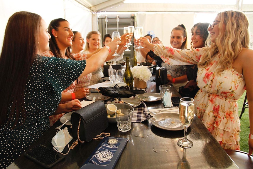 A group of work friends together at a Melbourne Cup function