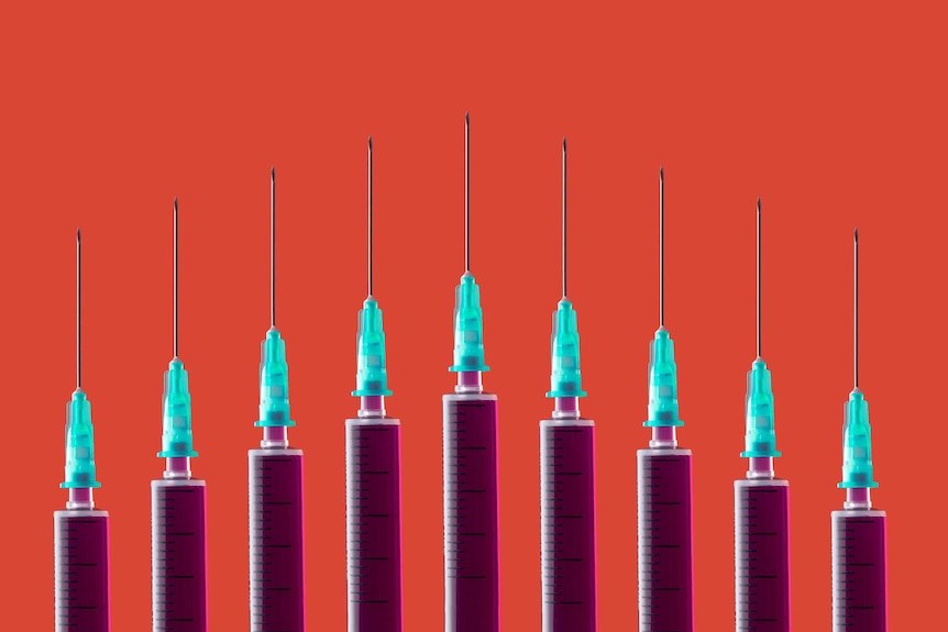 Multiple syringes organized in a pattern over orange background.
