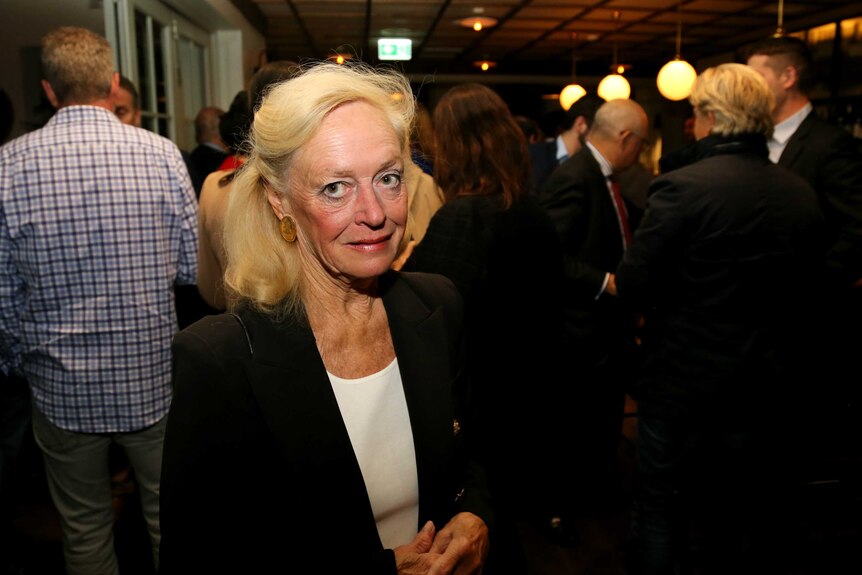 An older woman at a pub looking at the camera