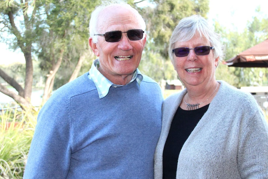 Man and woman Greg and Angela O'Brien -  both with tinted glasses looking at camera