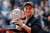 Ashleigh Barty holds the French Open trophy and smiles