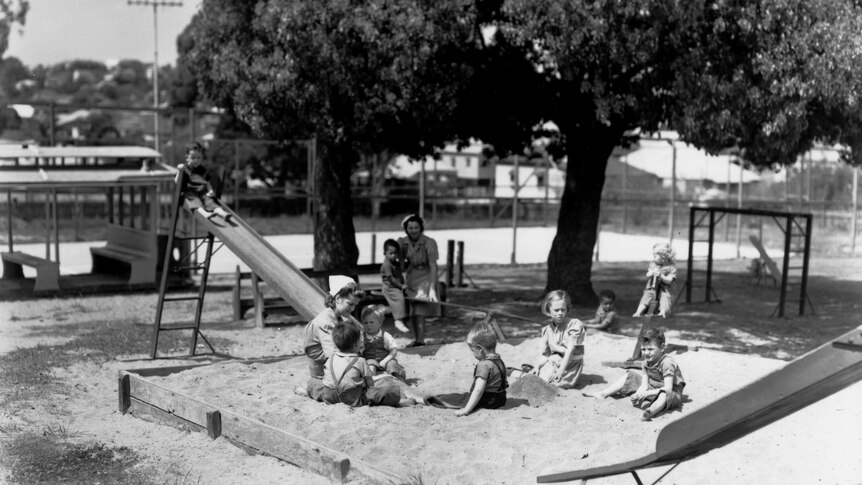 Children and adults in a playground at Diamantina Receiving Depot and Infants' Home around 1940