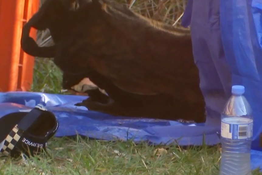 A black dress being turned over on top of a tarpaulin