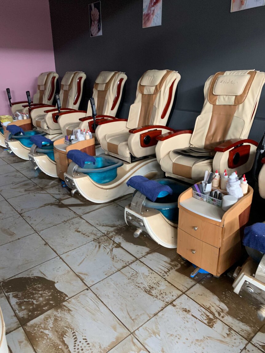 An empty nail salon is covered in dirt and mud after the Townsville floods.