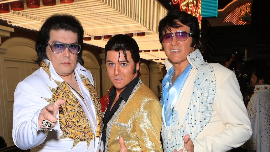 Three Elvis impersonators posing in costume