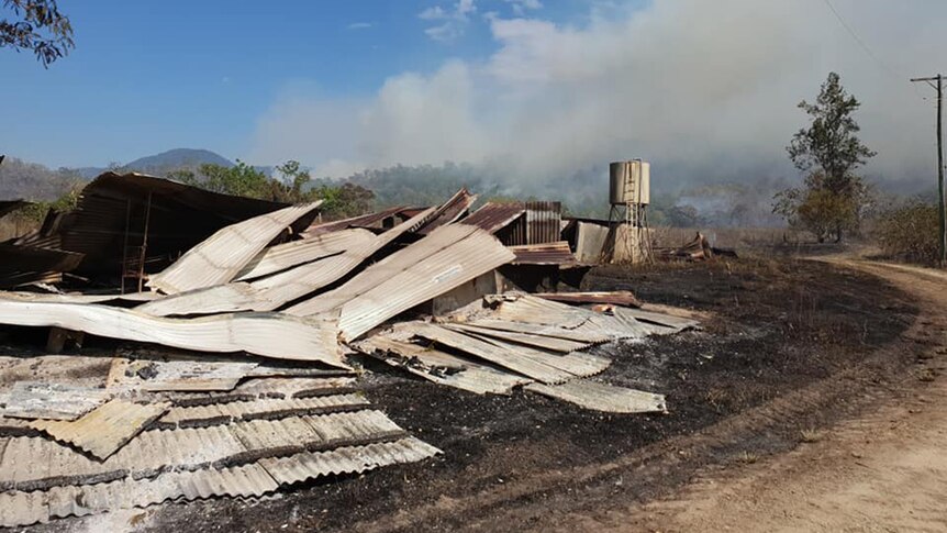 Debris and corrugated iron on ground after bushfire at Finch Hatton.