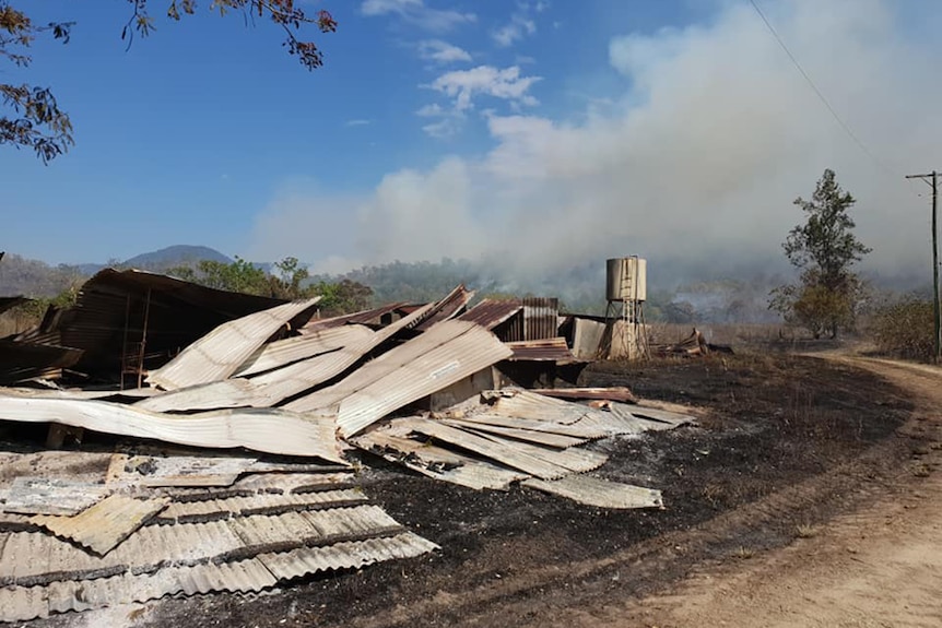 Debris and corrugated iron on ground after bushfire at Finch Hatton.