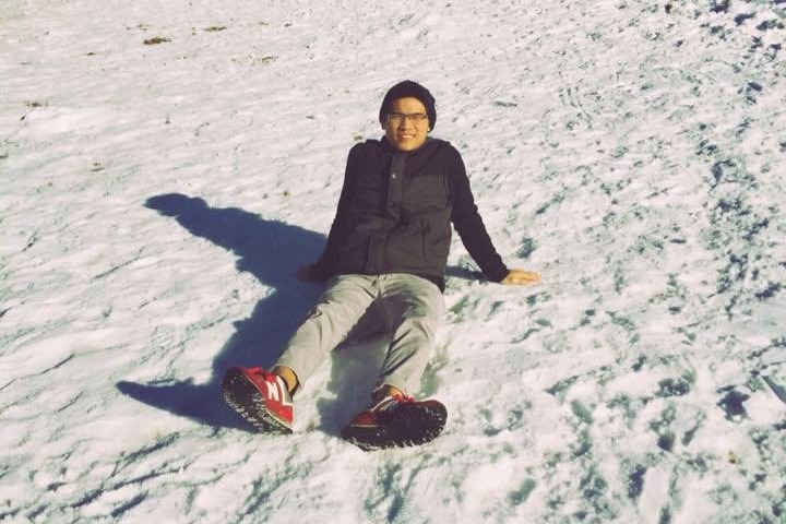 A young man sitting casually on a salt flat.