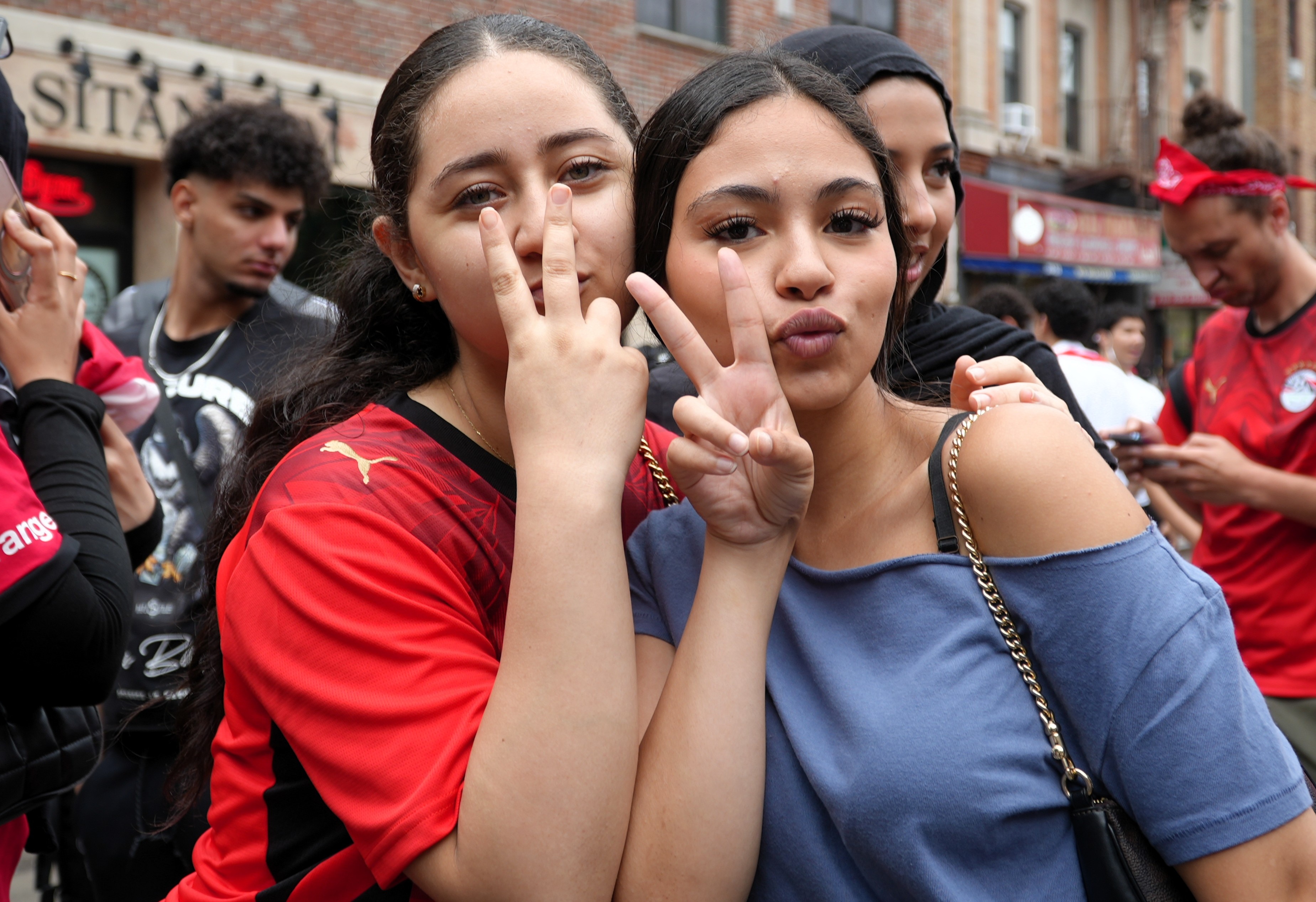 Two young women pose signalling peace signs