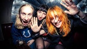 three women from  UK band Hotwax are photographed having fun in the back of a car