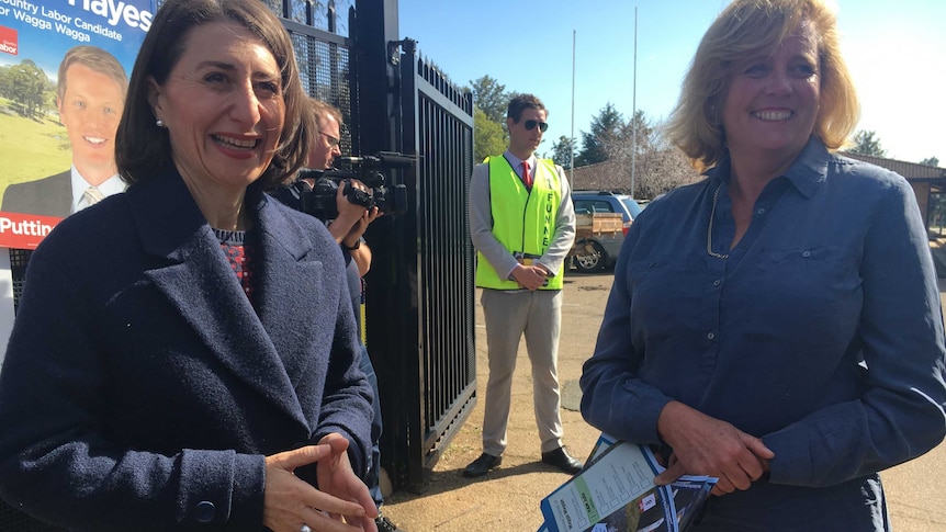 Gladys Berejiklian and Julia Ham stand in front of candidate posters at the Wagga Wagga by-election.