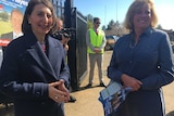 Gladys Berejiklian and Julia Ham stand in front of candidate posters at the Wagga Wagga by-election.