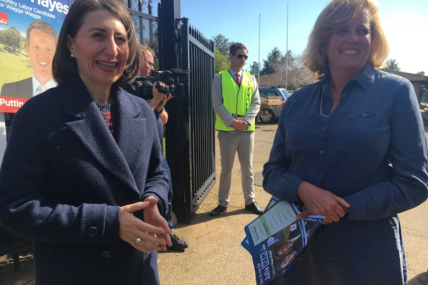 Gladys Berejiklian and Julia Ham stand in front of candidate posters at the Wagga Wagga by-election.