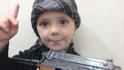 A Sharrouf child holds a gun and gives the Islamic State one finger salute.