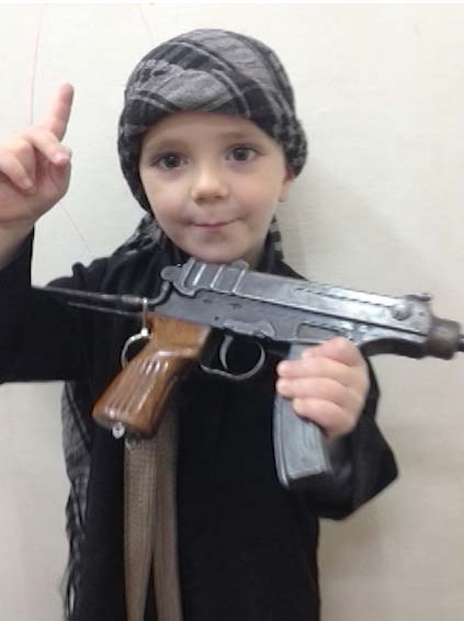 A Sharrouf child holds a gun and gives the Islamic State one finger salute.