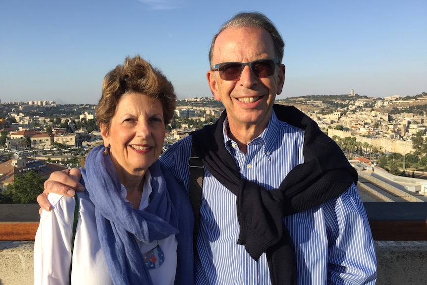 Jeff with arm around Violet Loewenstein facing camera with view behind them in Westbank