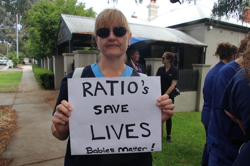 Serena, a nurse from King Edward Memorial Hospital with a sign saying ratios save lives