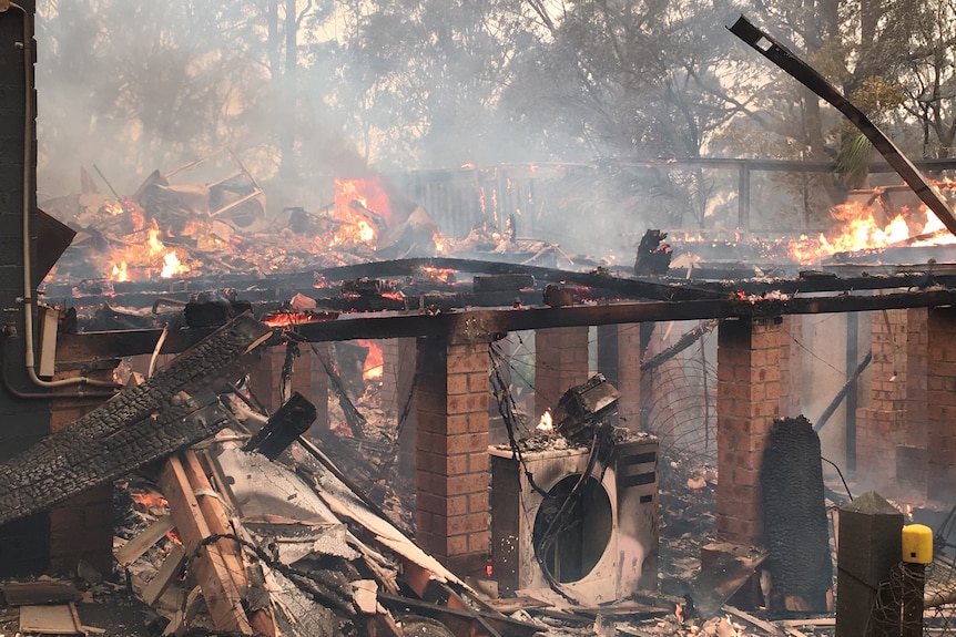 The mostly destroyed remains of a house on fire