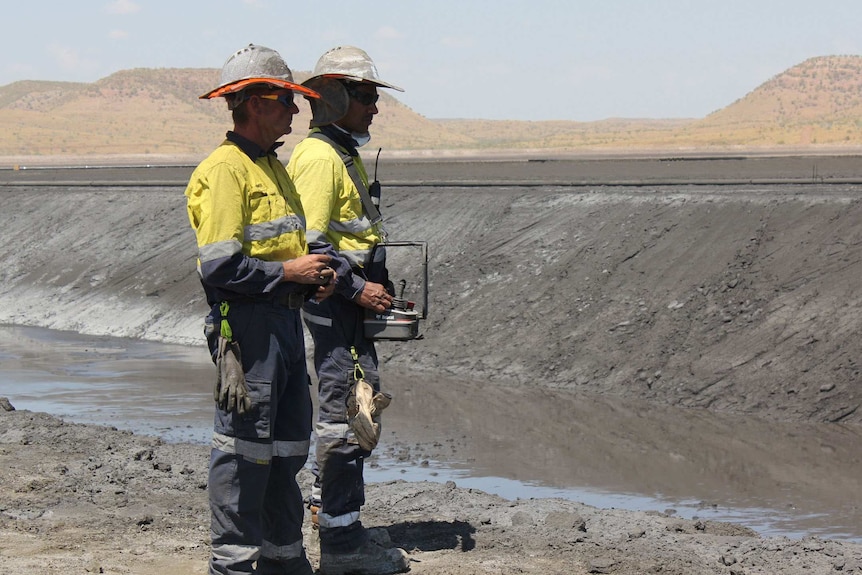 Workers operating high pressure hoses at Century Mine