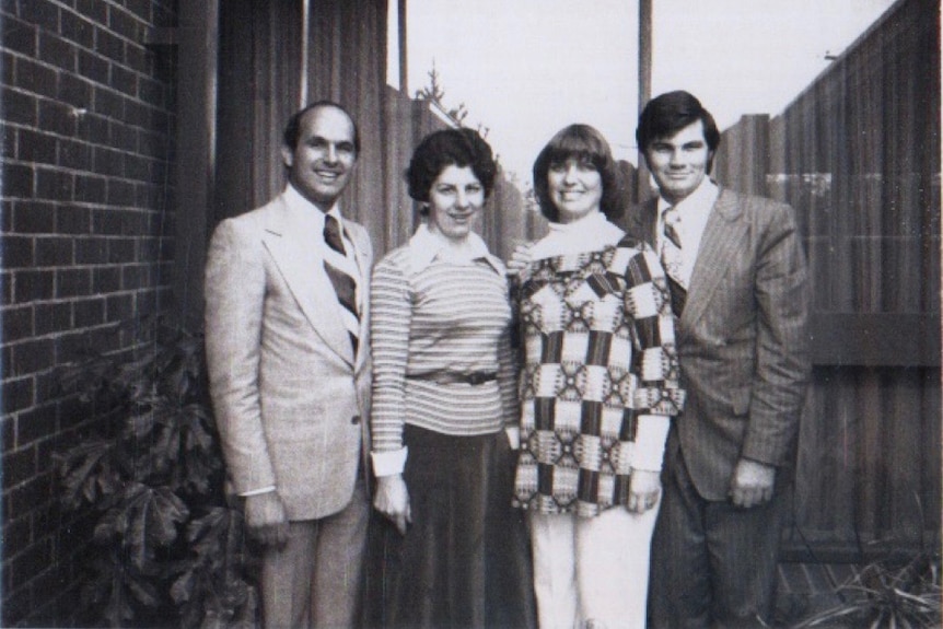 Medium black and white archive portrait shot of two men and two women posing outside for the camera.