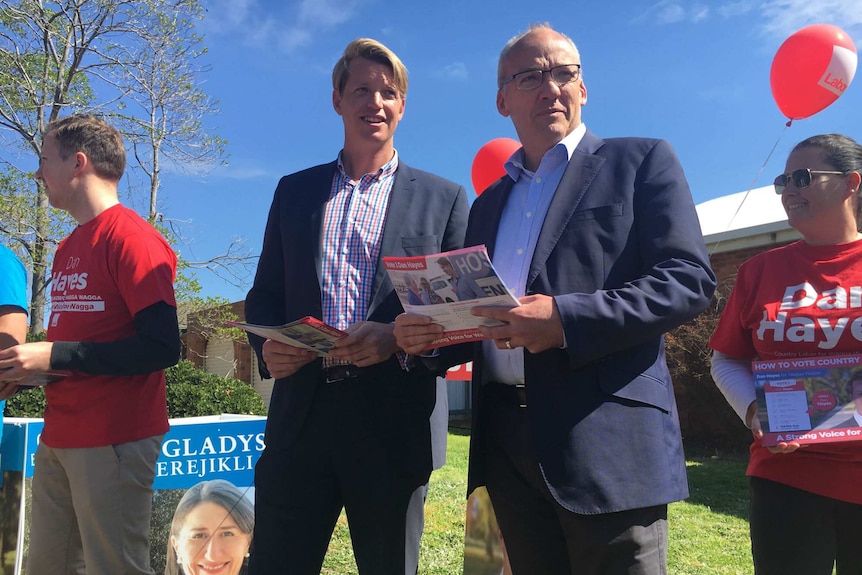 Luke Foley and Dan Hayes hold campaign posters for NSW Labor