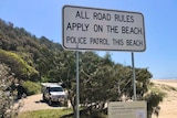 Road rules sign on sandy beach