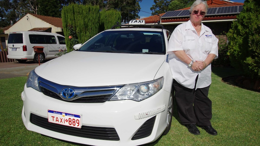 Perth taxi driver Pat Hart Hart stands alongside her white taxi in front of her house.