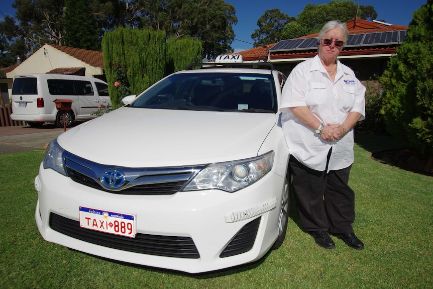 Perth taxi driver Pat Hart Hart stands alongside her white taxi in front of her house.