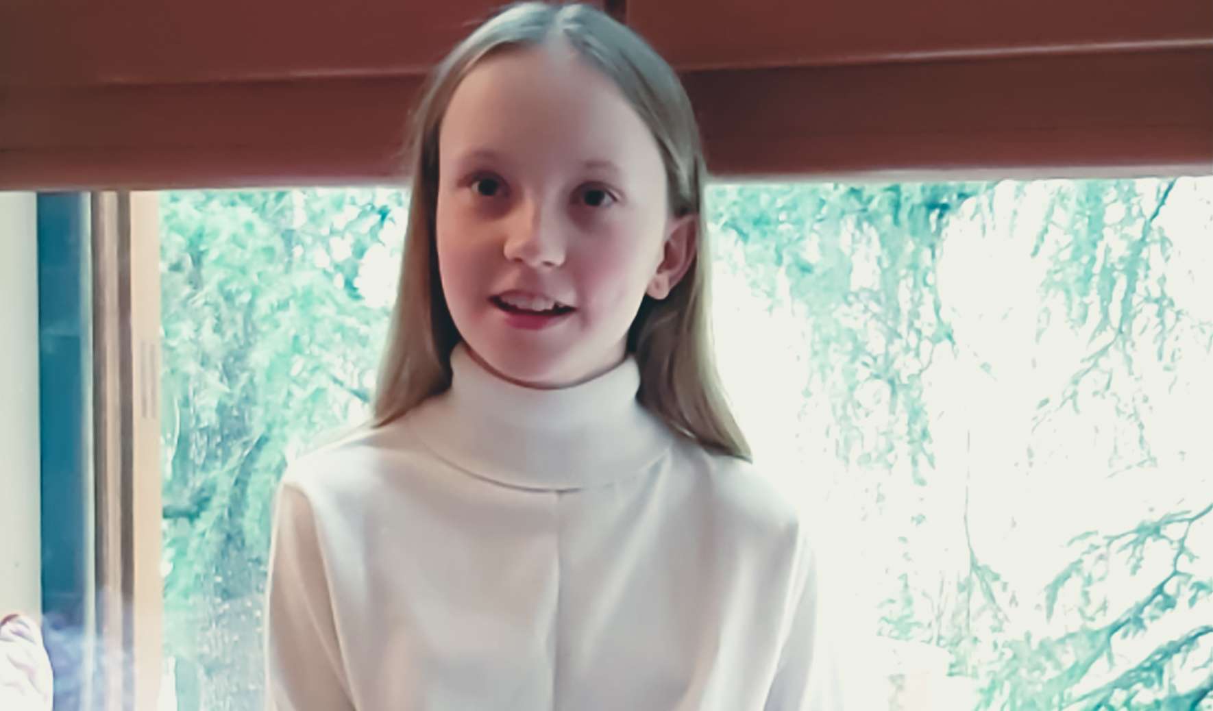 Annabel sits in front of a big window.