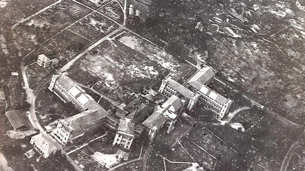 A black and white aerial photograph of a destroyed building.
