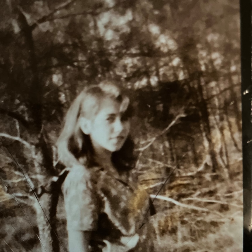 sepia tone image of young girl with trees in background