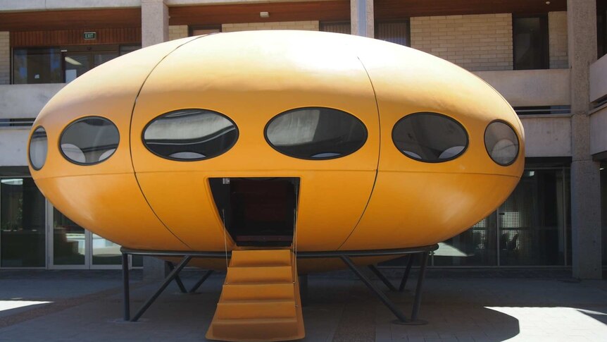 A yellow round UFO shaped house.