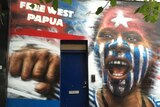 A mural with a woman with the red, blue and white morning star independence flag painted on her face