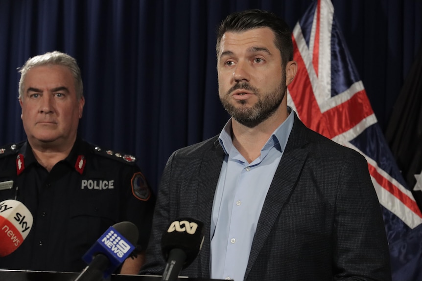 Brent Potter speaking at a press conference with his police commissioner Michael Murphy beside him