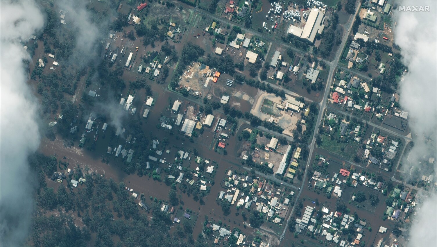 A satellite image shows Rochester with flood water through streets, homes and businesses