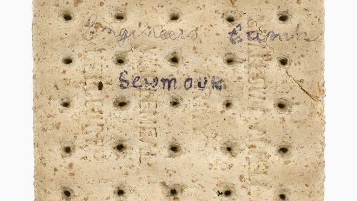 Square oat biscuit with the words Engineers Camp, Seymour, April 2nd to 25th 1917 written on one side.