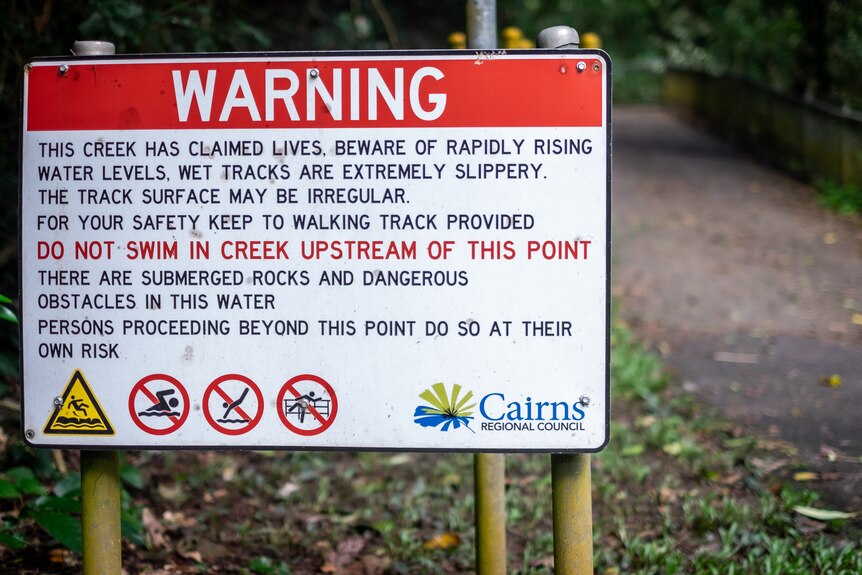 A warning sign against swimming in a rainforest.