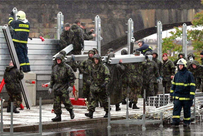 Soldiers work to erect flood barriers in Prague