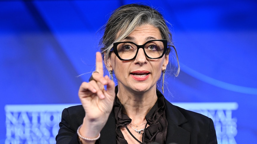  Francesca Albanese holds one finger up while addressing the National Press Club