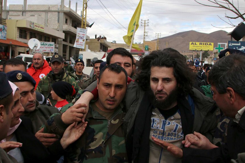 A Lebanese soldier helps a fellow member of the security forces moments after his release.