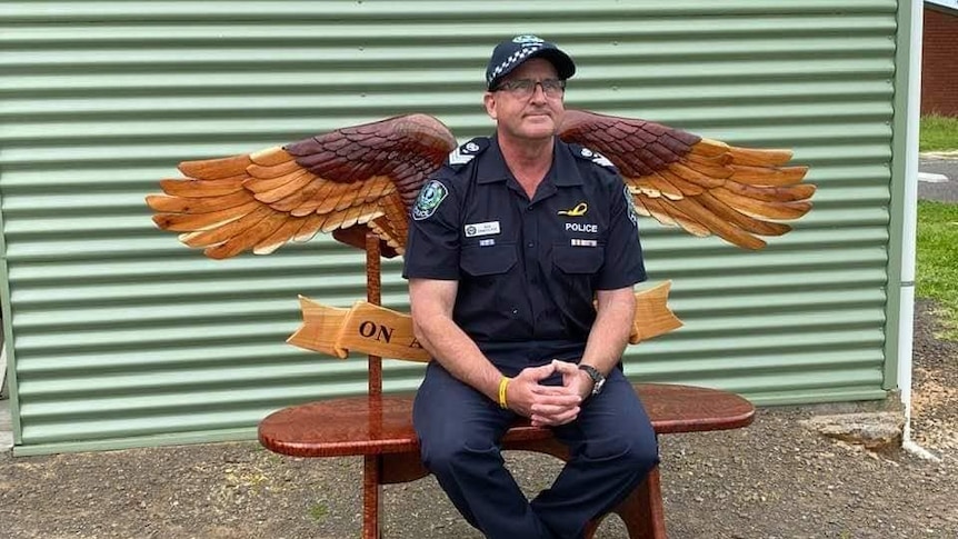 Man sits on bench with angel wings