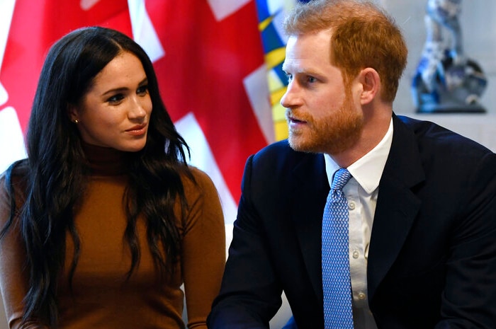 Prince Harry and Meghan Markle are sitting on a couch