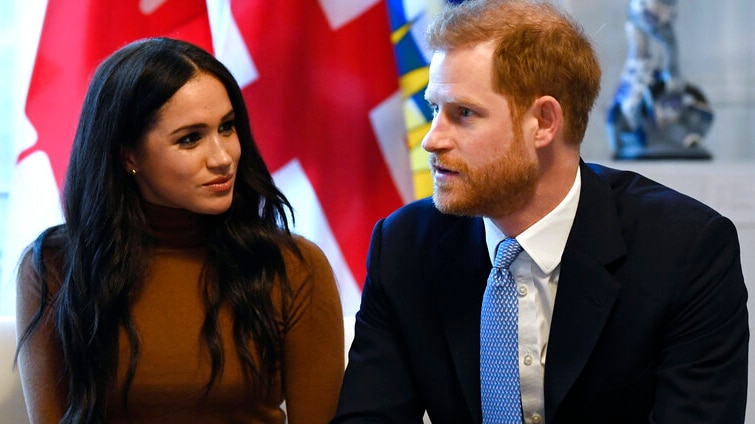 Prince Harry and Meghan Markle are sitting on a couch