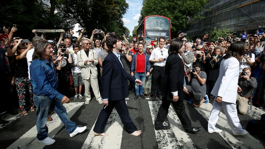 People crowd a zebra crossing