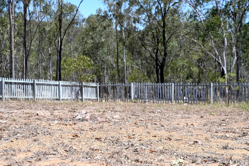 A white picket fence lines the border of dry corner of the old cemetery in Cherbourg believed to be the site of a mass grave.