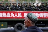 Pria Uyghur memandang tentara China di Xinjiang