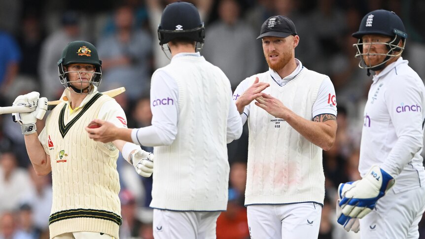 England captain Ben Stokes makes a T with his hands to review a catch of Australia batter Steve Smith, who is looking on.